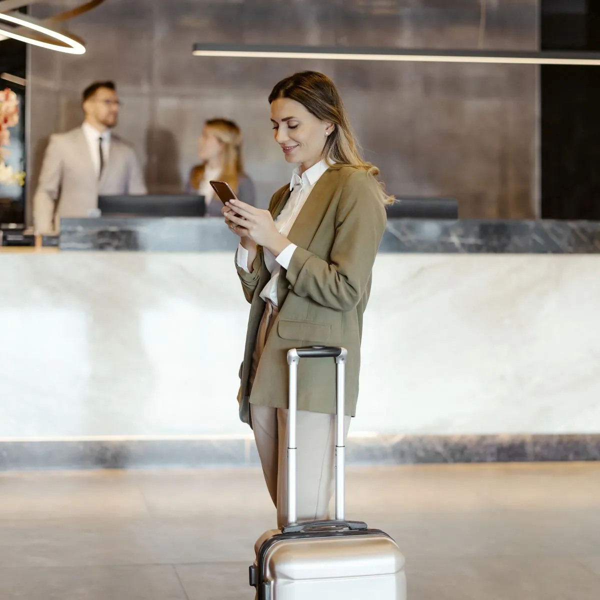 Geschäftsfrau mit Koffer in einer Hotellobby