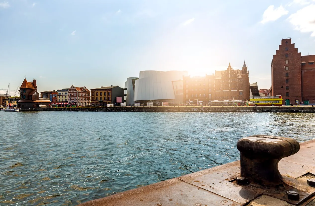 Hafen von Stralsund mit dem Ozeaneum und Backsteinspeichern im Gegenlicht der Sonne