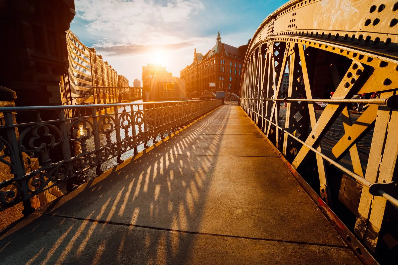 Sonnenlicht fällt über eine historische Stahlbrücke in der Hamburger Speicherstadt